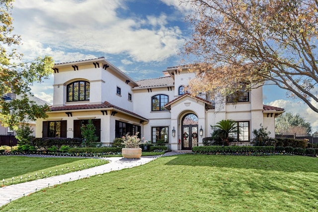 mediterranean / spanish-style house with french doors and a front lawn