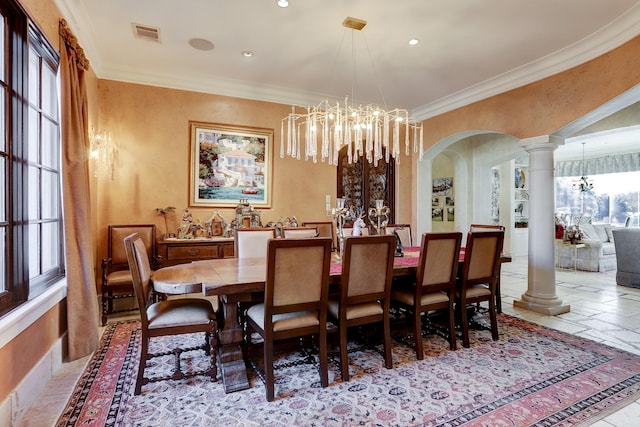 dining space with crown molding, a chandelier, and decorative columns