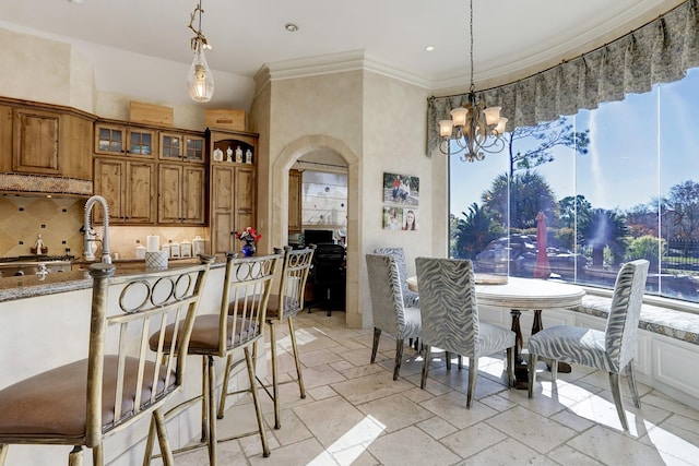 dining space with ornamental molding and a chandelier