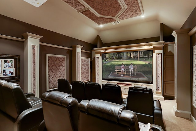 carpeted home theater featuring decorative columns and vaulted ceiling