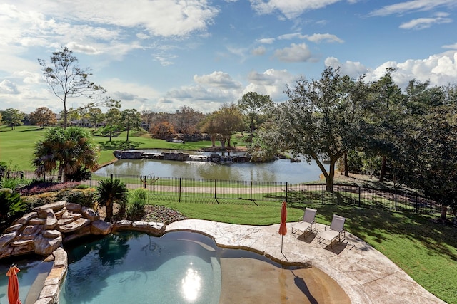 view of pool featuring a lawn, a patio, and a water view