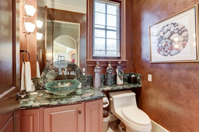 bathroom with crown molding, vanity, and toilet