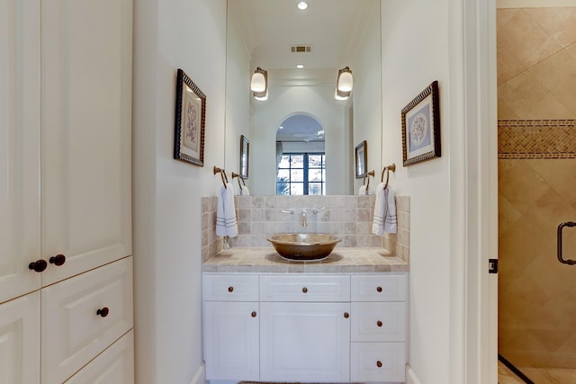 bathroom with vanity, backsplash, and a shower with shower door