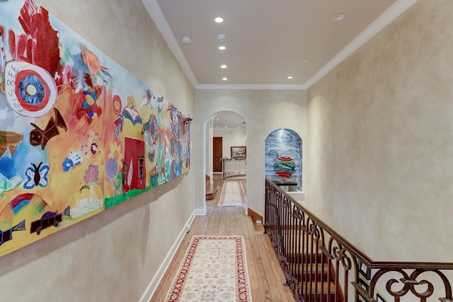 hallway with light hardwood / wood-style flooring and ornamental molding