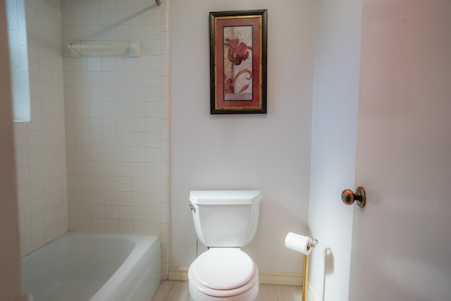 bathroom with tiled shower / bath combo and toilet