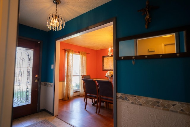 entryway with a textured ceiling and an inviting chandelier