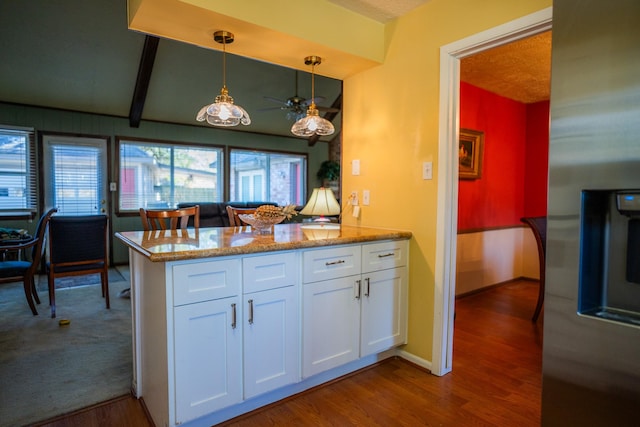 kitchen featuring light stone counters, white cabinets, stainless steel fridge with ice dispenser, decorative light fixtures, and kitchen peninsula