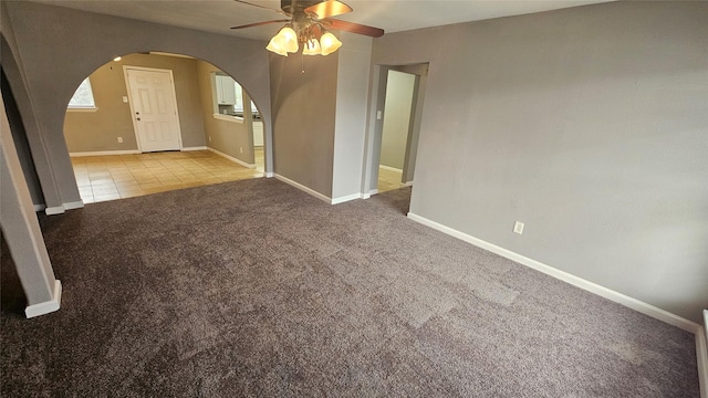 carpeted spare room featuring ceiling fan