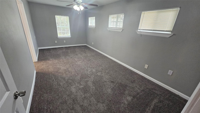 empty room with dark carpet and ceiling fan