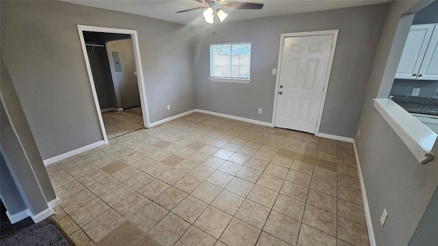 interior space with light tile patterned floors and ceiling fan