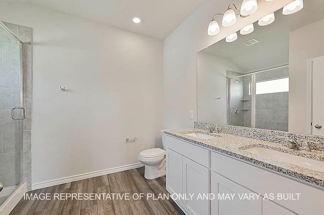 bathroom featuring vanity, hardwood / wood-style flooring, a shower with door, and toilet