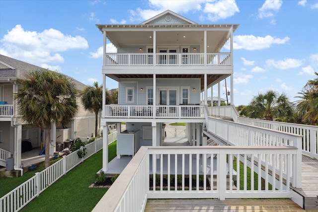 rear view of house with a balcony and a lawn