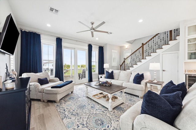 living room featuring ceiling fan, wine cooler, and light hardwood / wood-style floors