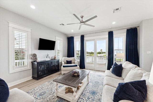 living room with light hardwood / wood-style flooring and ceiling fan