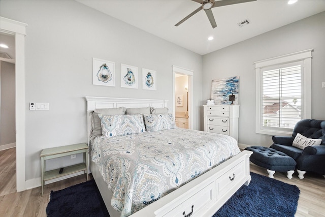 bedroom with ceiling fan, connected bathroom, and light hardwood / wood-style floors