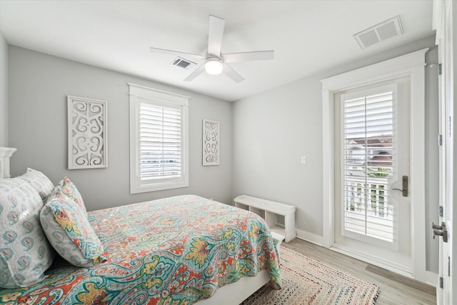 bedroom featuring ceiling fan, light hardwood / wood-style flooring, multiple windows, and access to outside