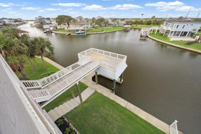 view of dock with a lawn and a water view