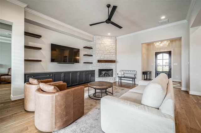 living room featuring crown molding, a fireplace, and light hardwood / wood-style flooring