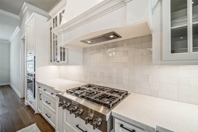 kitchen featuring white cabinets, custom range hood, and backsplash