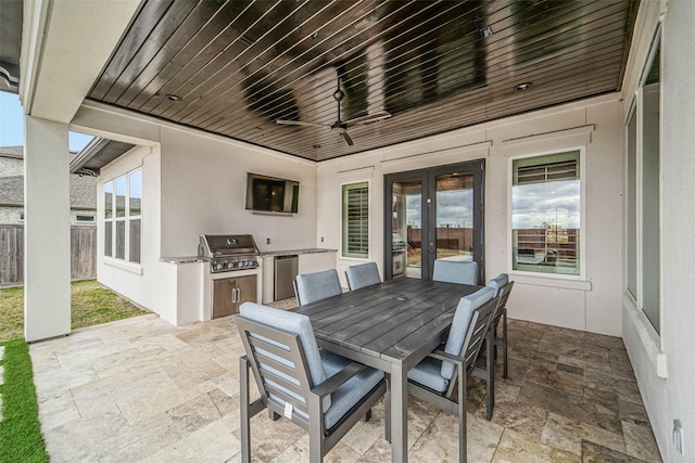 view of patio with grilling area, ceiling fan, and exterior kitchen