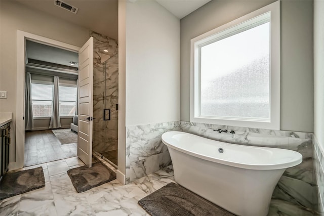 bathroom featuring tile walls, vanity, and independent shower and bath