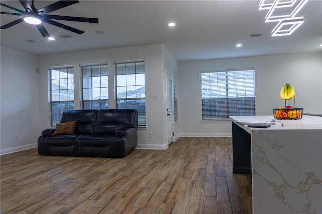 living room featuring dark wood-type flooring and ceiling fan