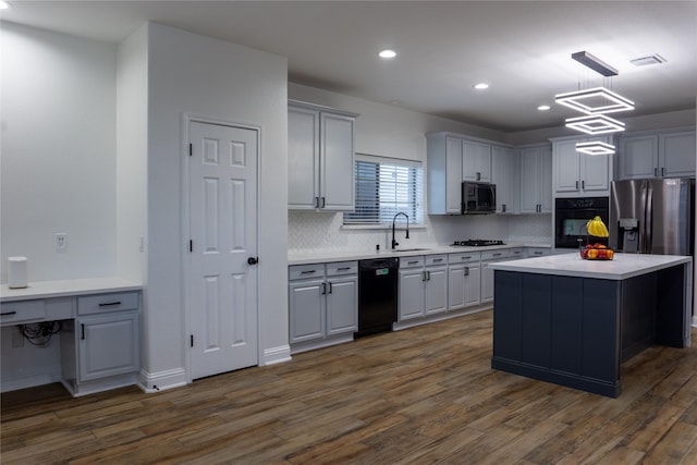 kitchen with a kitchen island, dark hardwood / wood-style flooring, decorative backsplash, hanging light fixtures, and black appliances