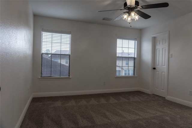 carpeted spare room featuring a healthy amount of sunlight and ceiling fan