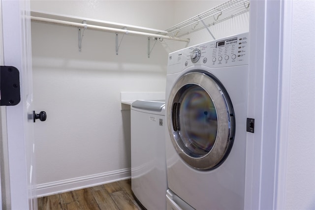 laundry room featuring dark wood-type flooring and washer and dryer