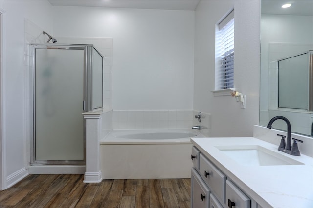 bathroom featuring vanity, hardwood / wood-style floors, and plus walk in shower