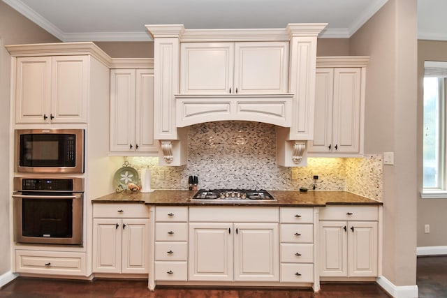 kitchen featuring dark stone countertops, backsplash, stainless steel appliances, dark hardwood / wood-style floors, and ornamental molding