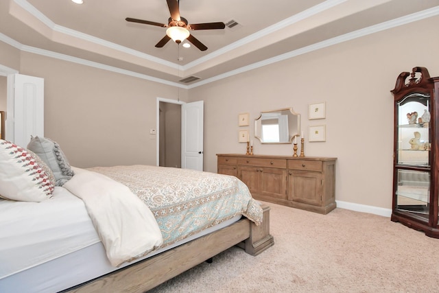 bedroom featuring ornamental molding, light colored carpet, ceiling fan, and a tray ceiling