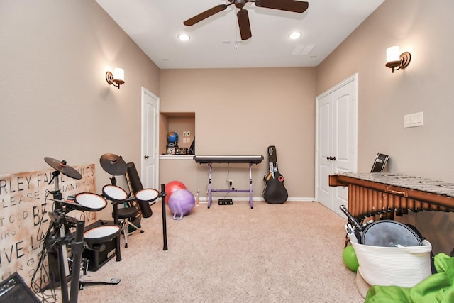 workout area featuring light colored carpet and ceiling fan