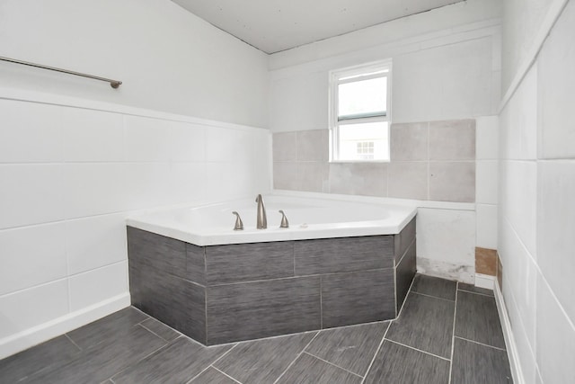 bathroom featuring tiled bath and tile walls