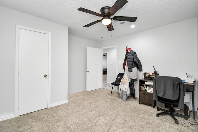 carpeted office space featuring a textured ceiling and ceiling fan