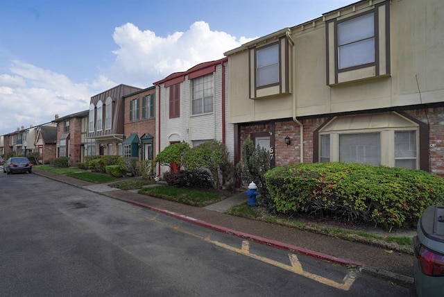 view of front facade with a residential view and brick siding