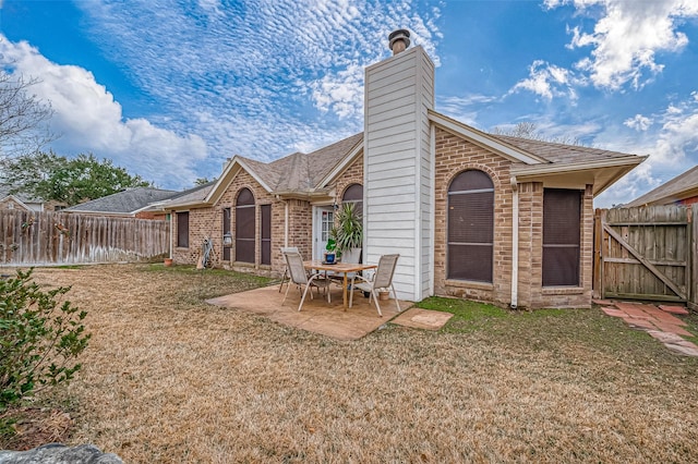 rear view of property featuring a patio and a yard