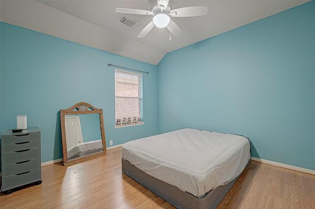 bedroom with vaulted ceiling, ceiling fan, and light hardwood / wood-style floors