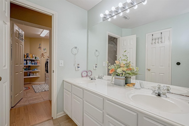 bathroom with tile patterned flooring, vanity, and washer / clothes dryer