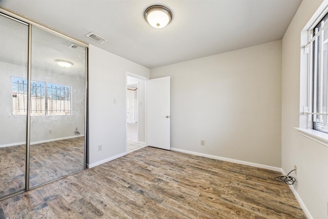 unfurnished bedroom with hardwood / wood-style floors and a closet