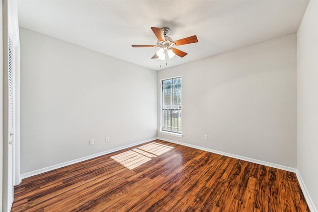 spare room featuring dark wood-type flooring and ceiling fan