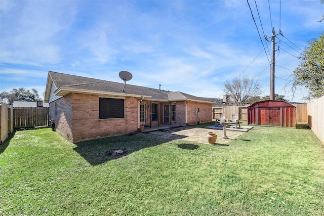 rear view of house featuring a storage shed, a yard, and a patio