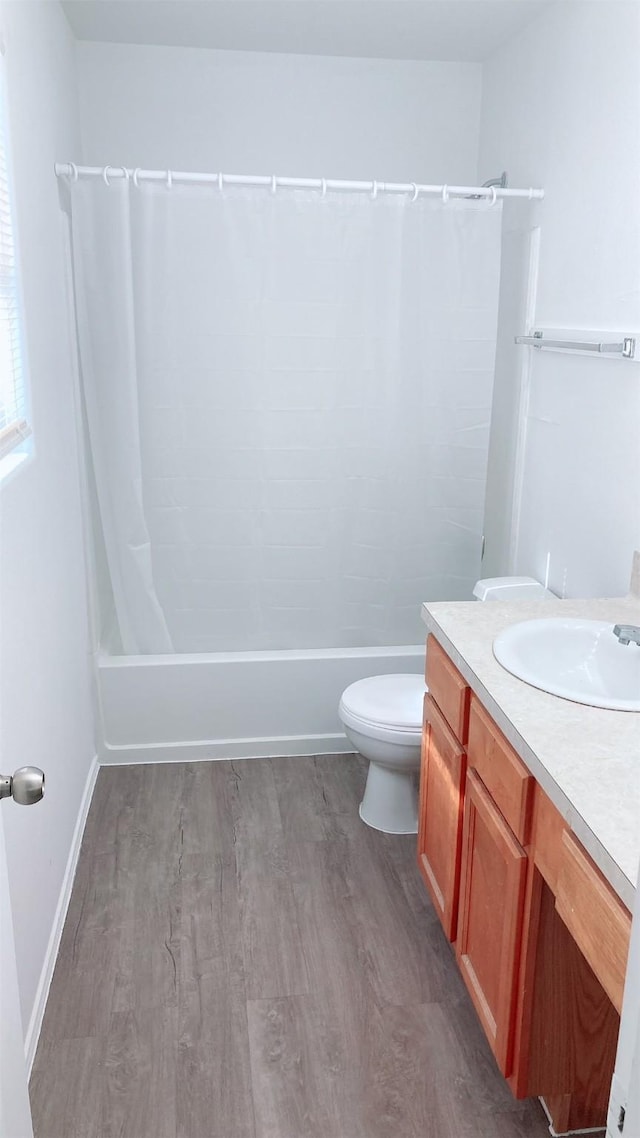 full bathroom with vanity, hardwood / wood-style flooring, toilet, and shower / bath combo with shower curtain