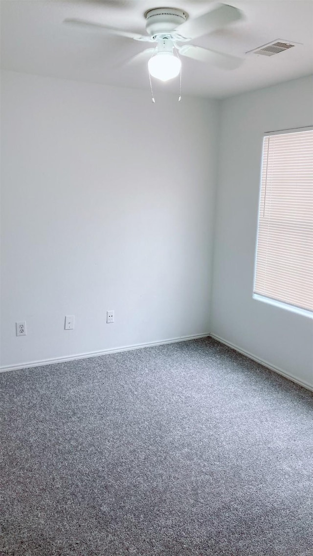 carpeted spare room featuring ceiling fan