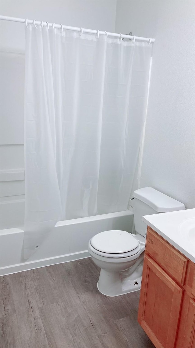 full bathroom featuring shower / bathtub combination with curtain, wood-type flooring, toilet, and vanity