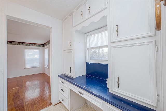 interior space with built in desk and light hardwood / wood-style floors