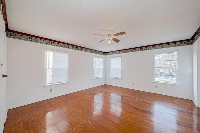 empty room with hardwood / wood-style floors and ceiling fan