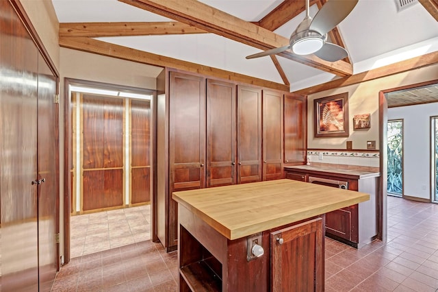 kitchen featuring wooden counters, lofted ceiling with beams, a kitchen island, ceiling fan, and tile patterned flooring