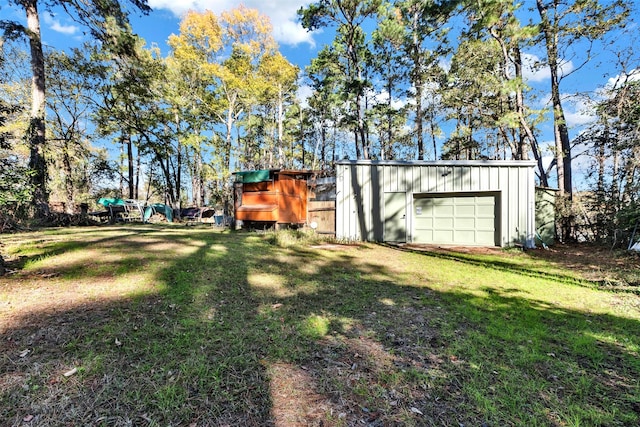 view of yard featuring a detached garage and driveway