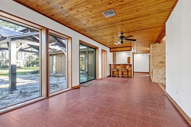 unfurnished sunroom with wood ceiling, ceiling fan, and indoor bar